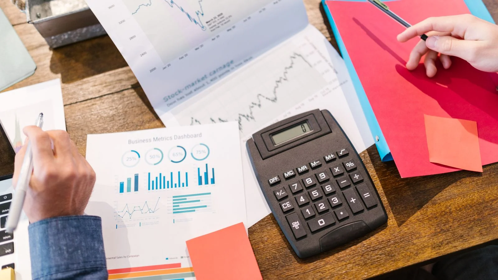 Graphs, a calculator, and financial analysis tools on a table, like the data behind a strong case study