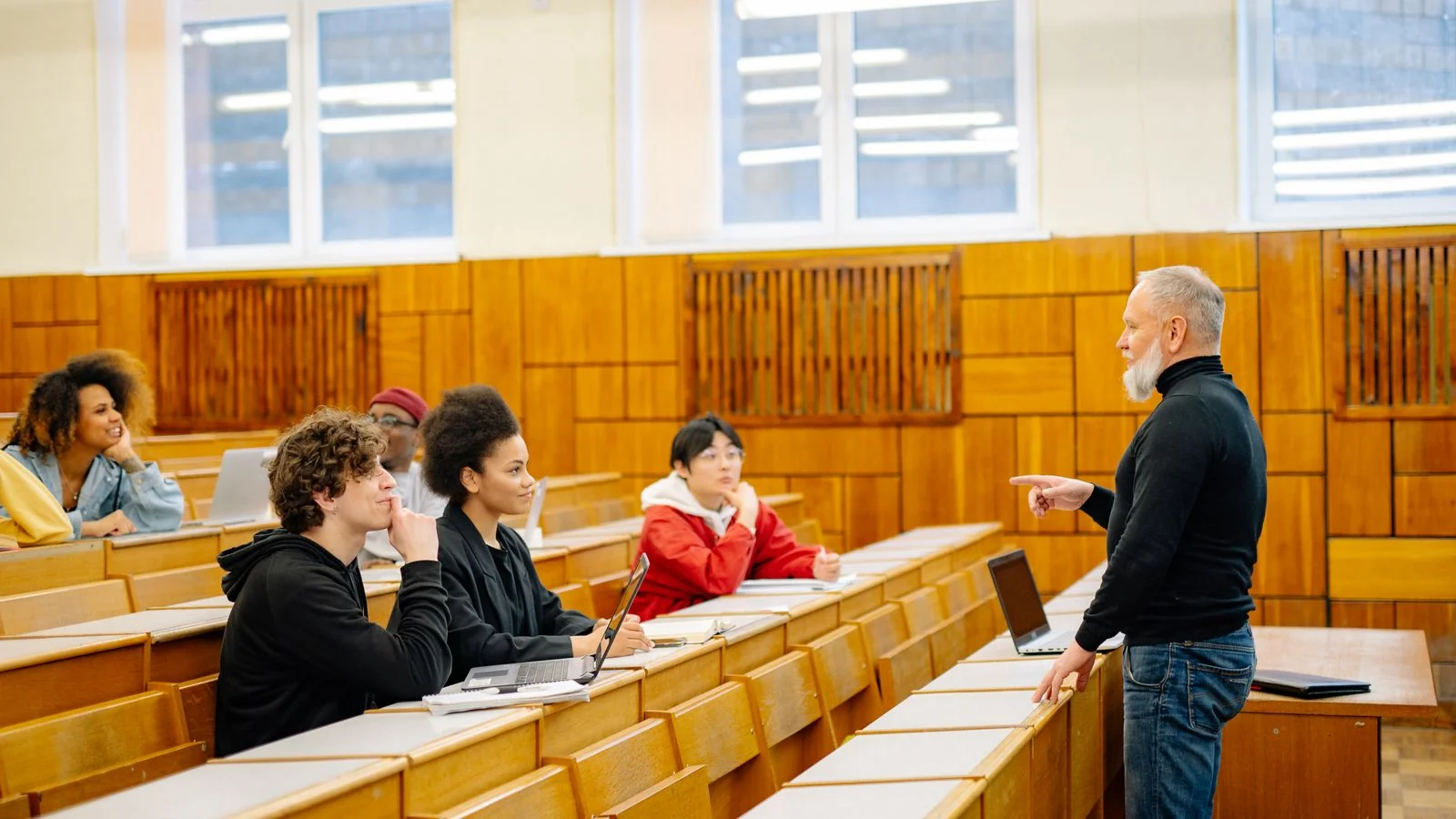 Professor leading a lively discussion with university students in a classroom, the audience Advice pieces serve