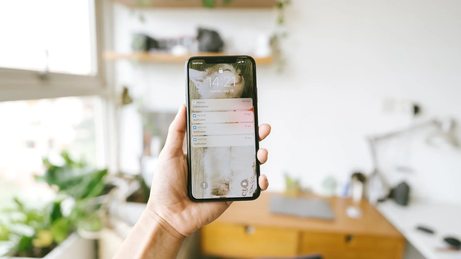 A hand holding a smartphone showing notifications, where most newsletters get deleted in seconds.