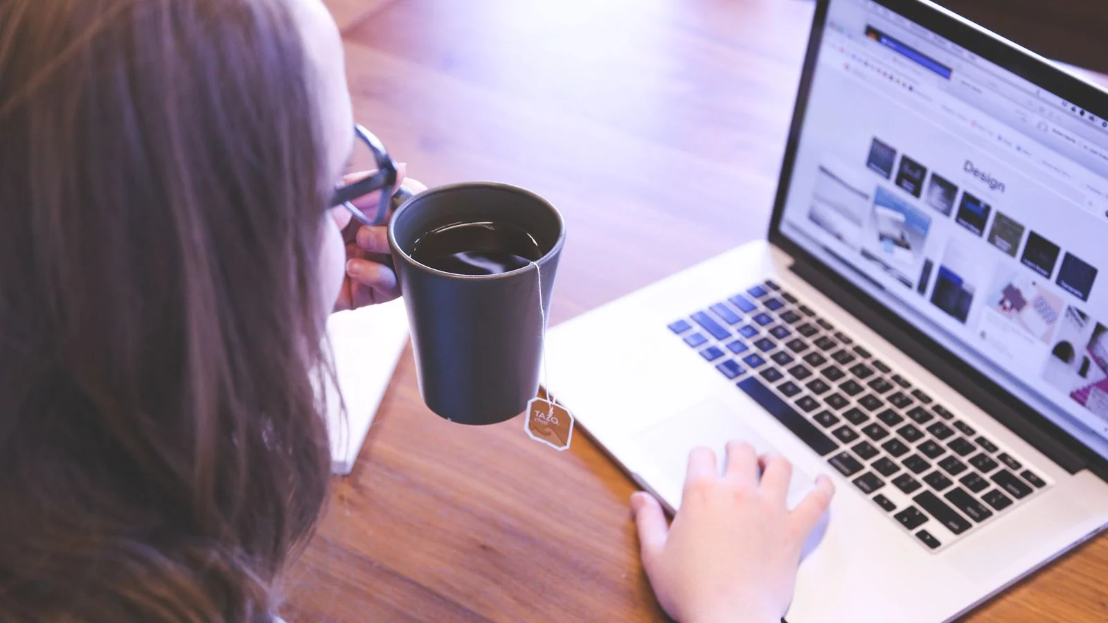 A visitor browsing a website on a laptop with coffee, deciding in seconds whether to stay or leave