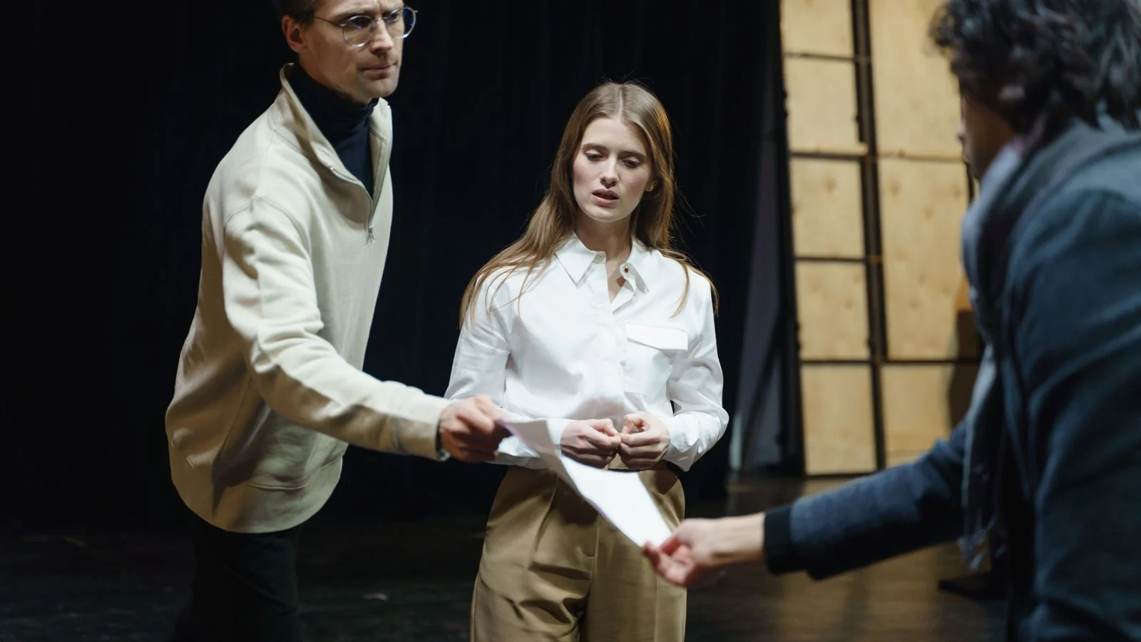 Actors rehearsing on stage and exchanging scripts, the kind of work that earns IMDb credits