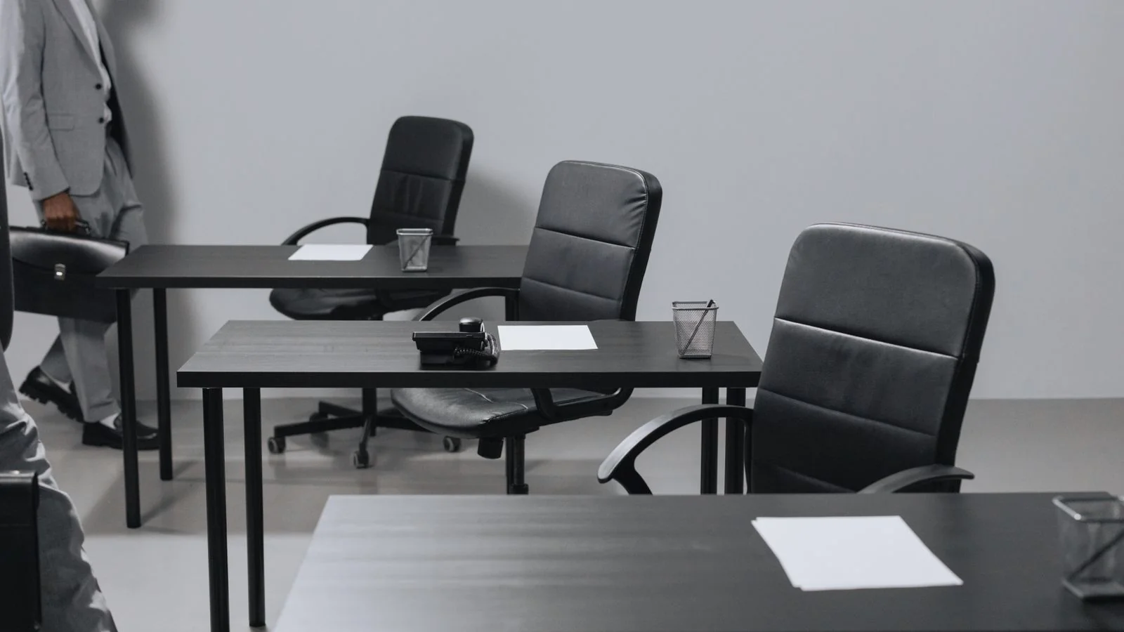 Empty modern office with black leather chairs and desks after newsroom cutbacks