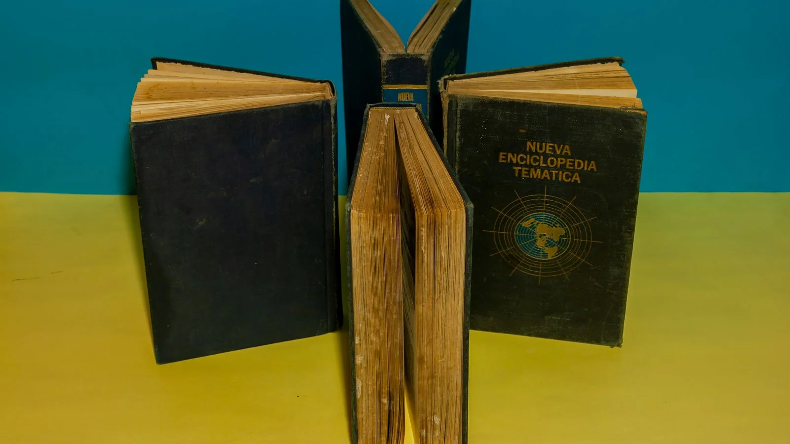 Vintage encyclopedia books arranged on a blue and yellow background, the reference sources behind panels