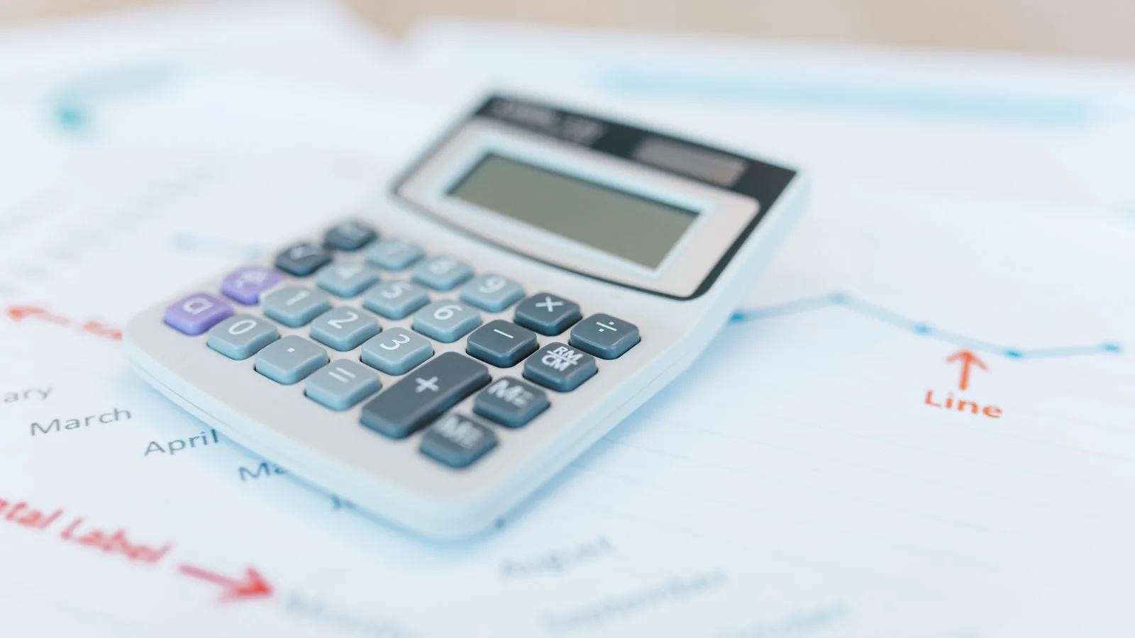 Calculator resting on financial documents with charts, the math behind a link budget