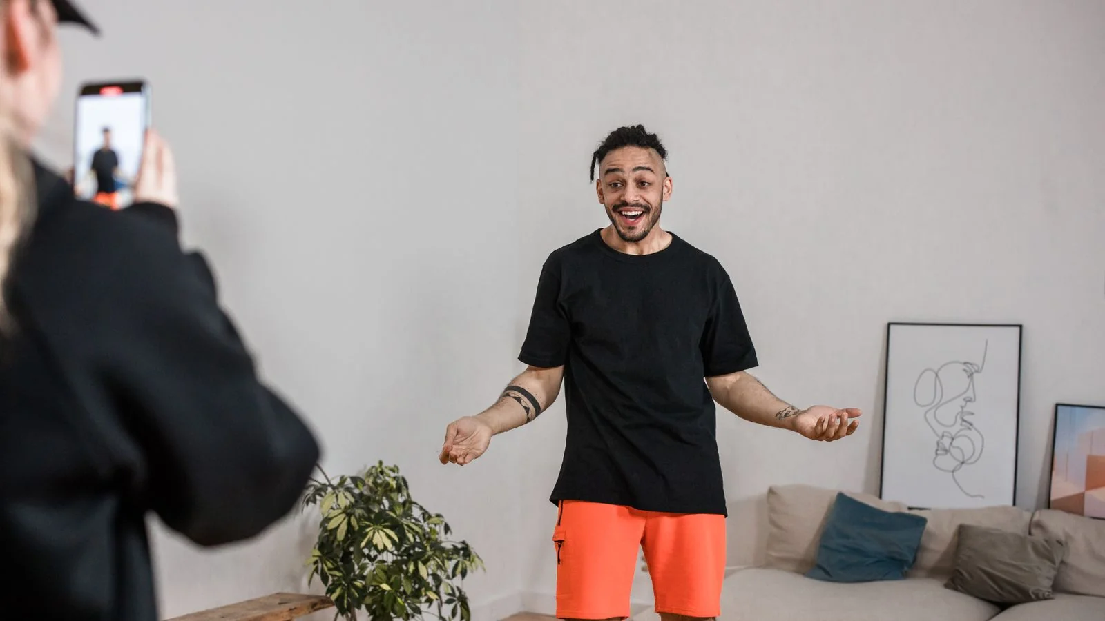 Creator filming a short vertical video on a smartphone indoors