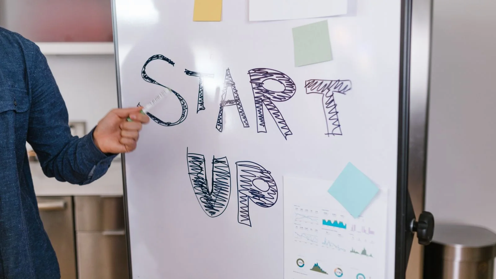 Founder pointing at a whiteboard while mapping out a startup plan