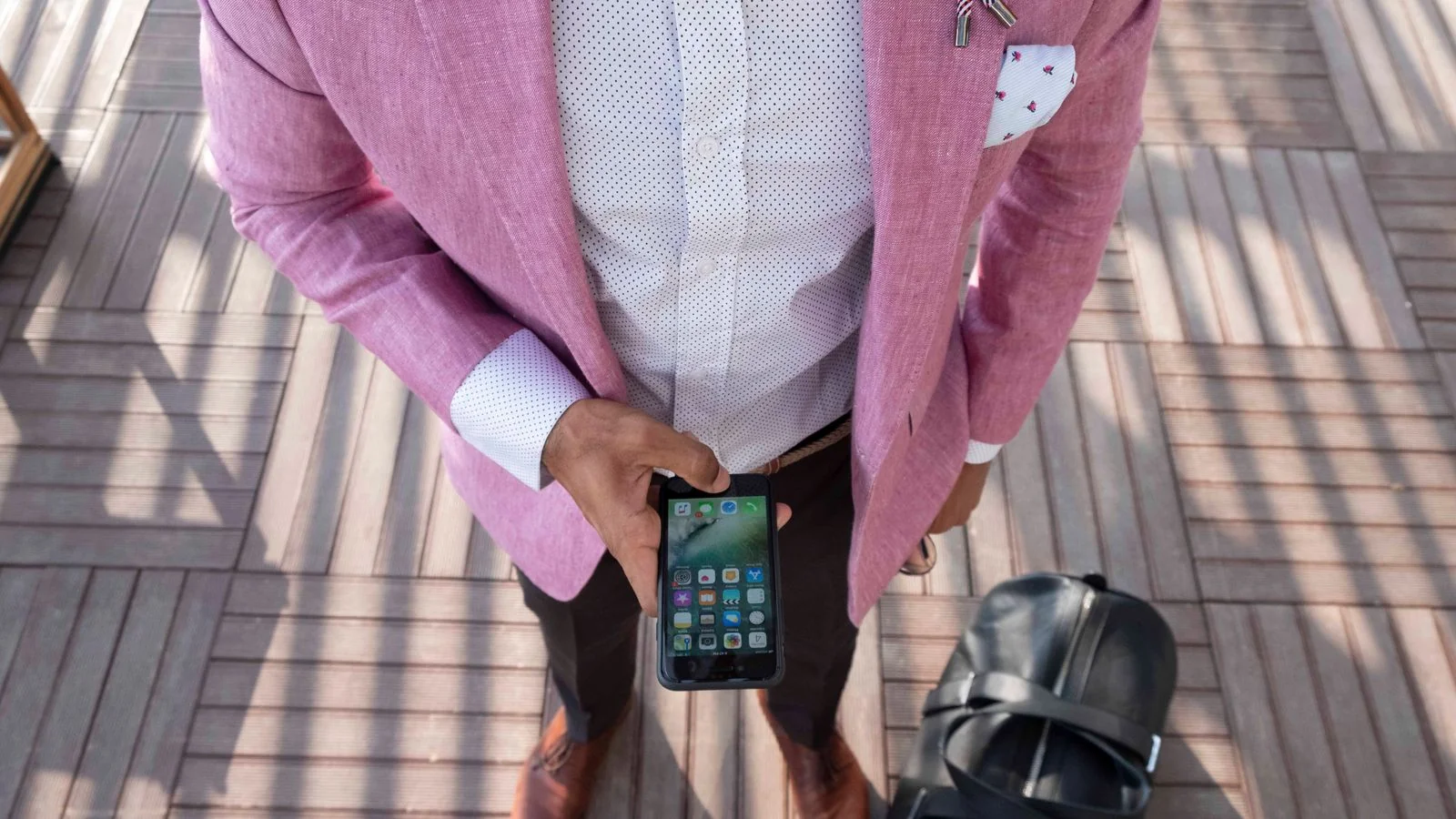 Man checking his smartphone while traveling, a snapshot of LinkedIn's mobile, on-the-go audience