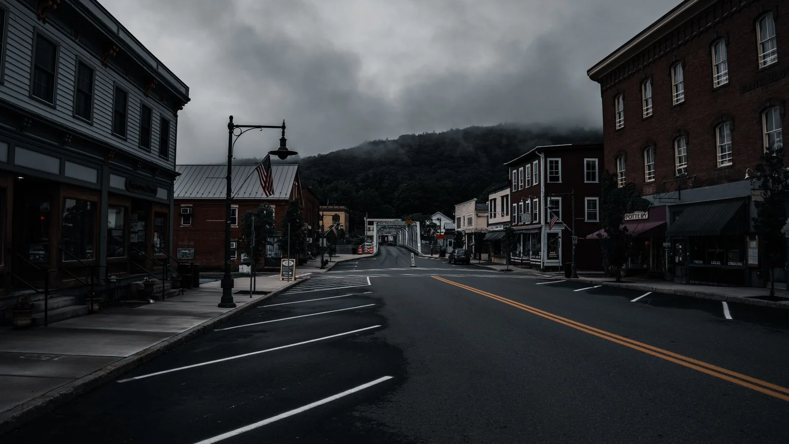 Empty street in a small town with historic buildings under moody clouds