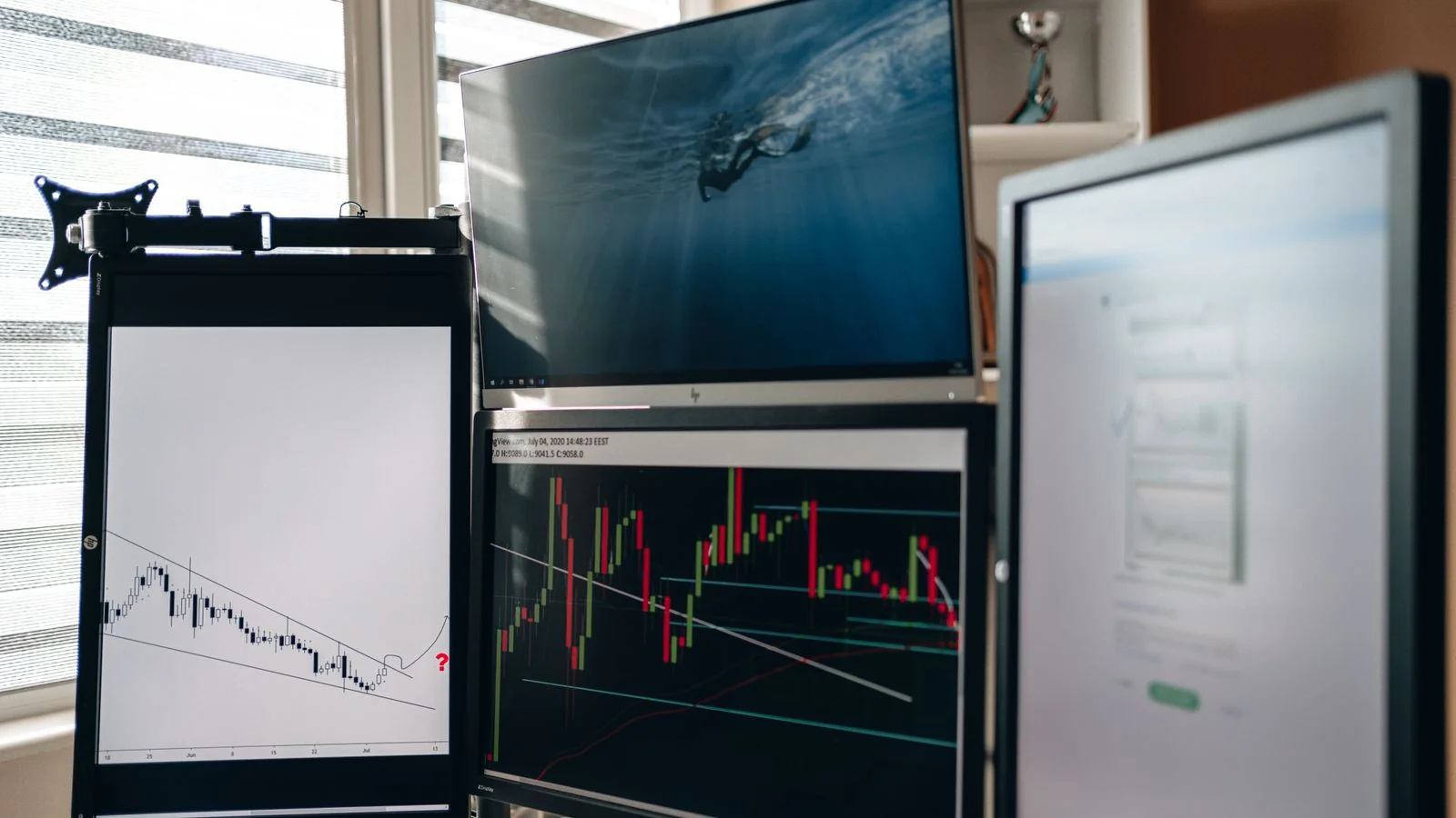 A workspace with multiple monitors showing charts and streams of data being watched continuously