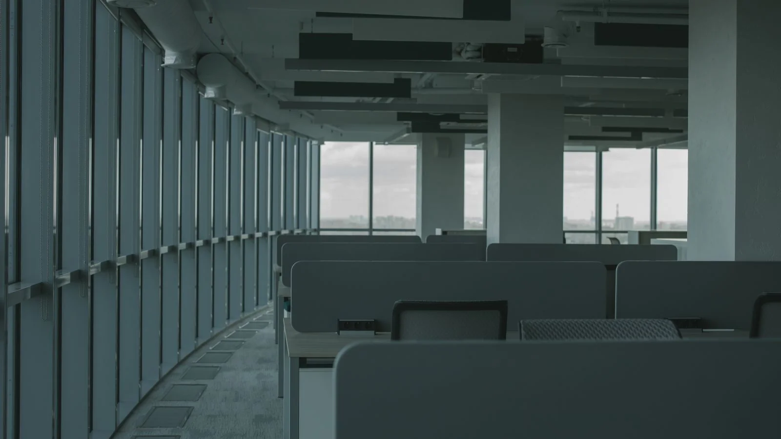 Empty office interior with modern desks and large windows