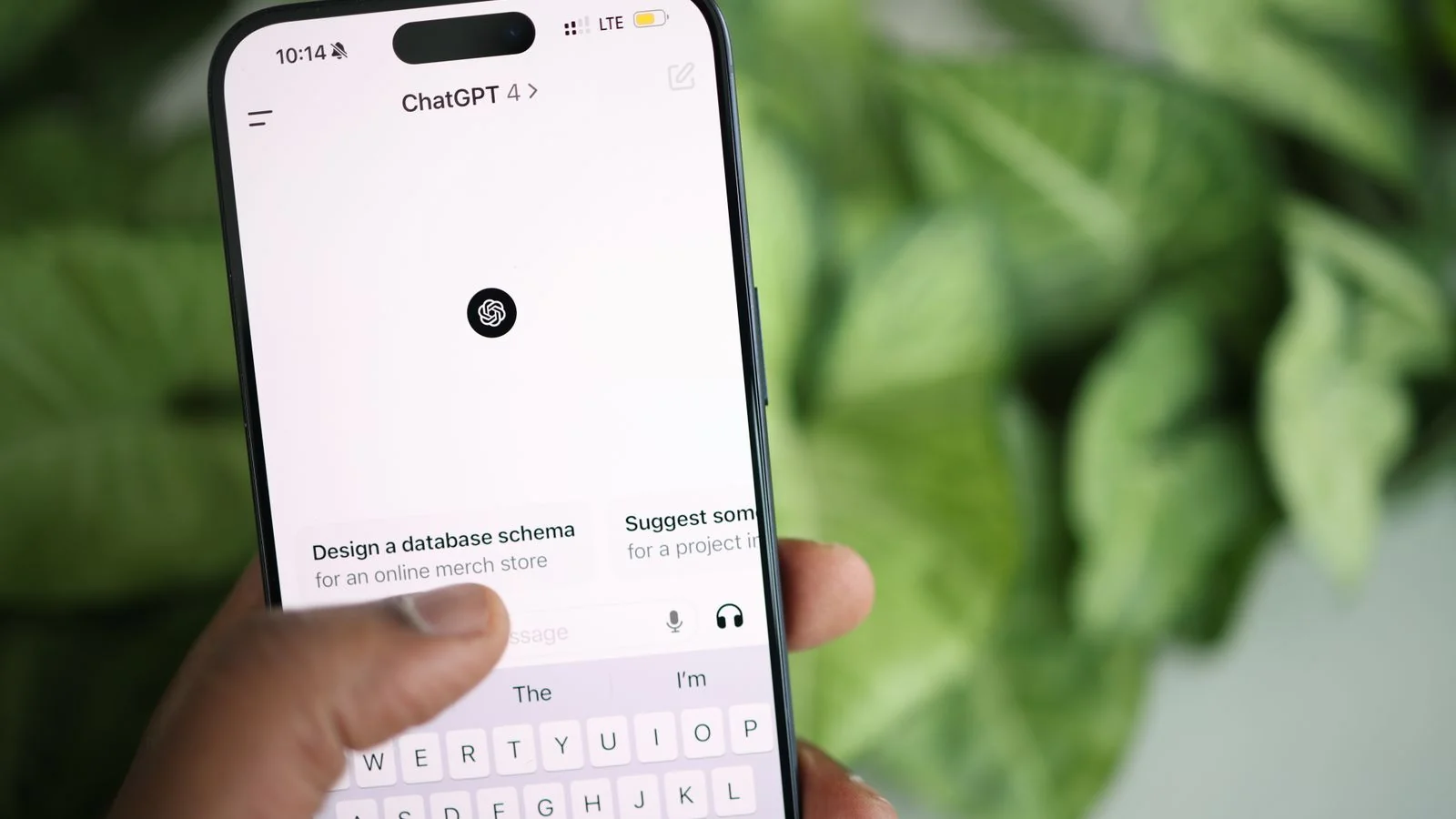 Hand holding a phone showing the ChatGPT interface, where brands track AI answers about them