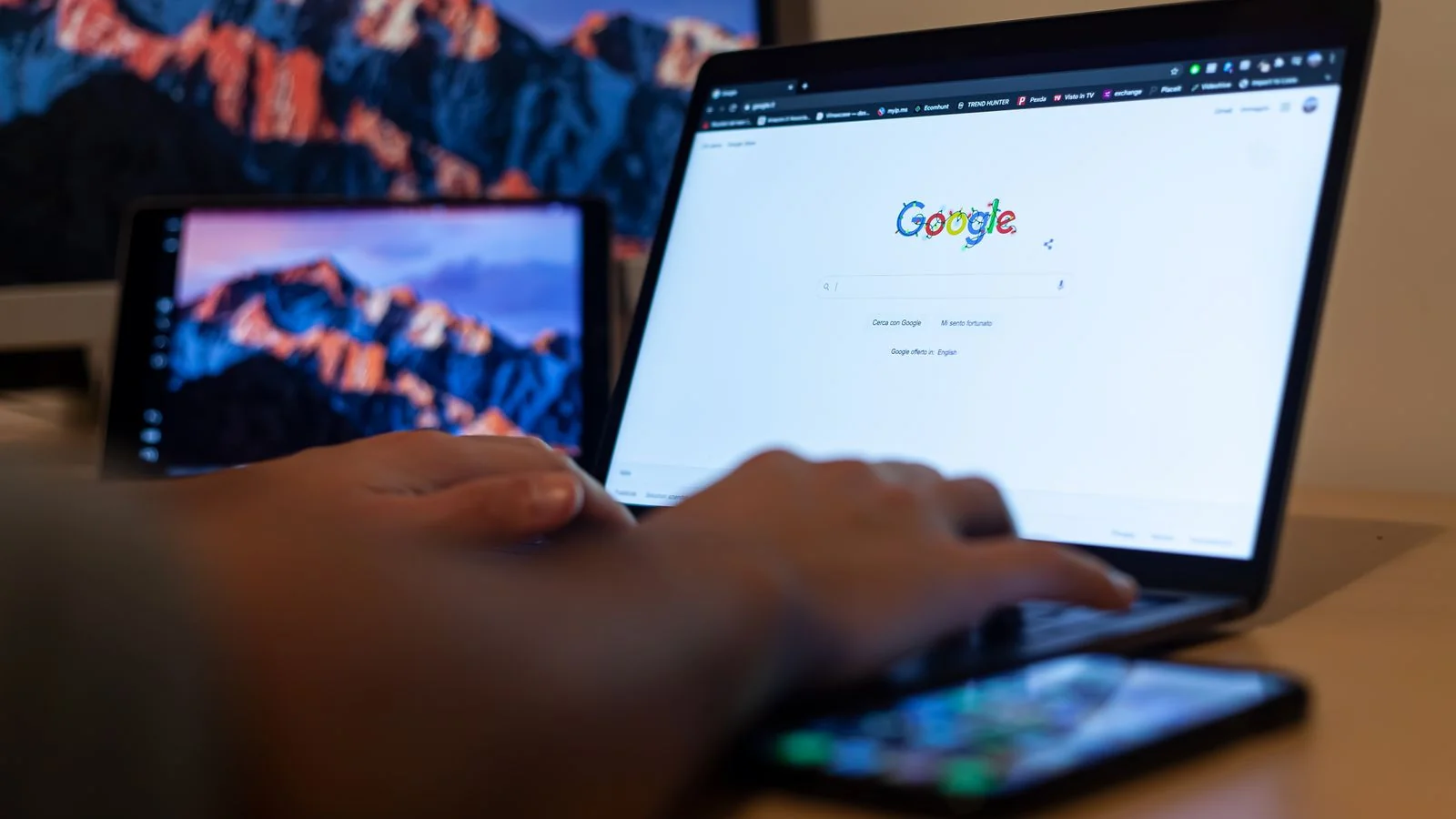Hands typing on a laptop with a search page open, researching a question