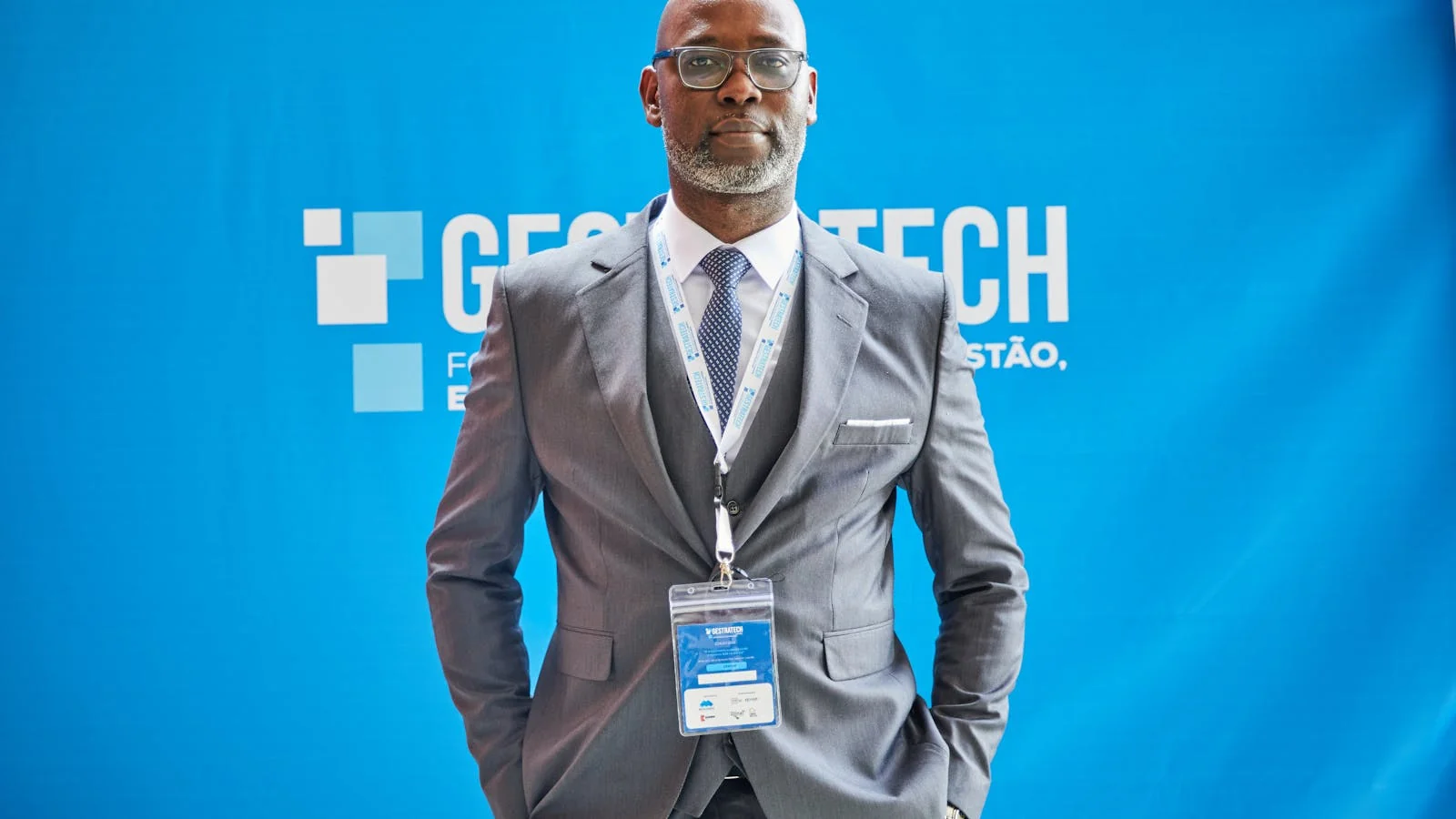 Founder at a trade-show booth in front of a blue branded backdrop