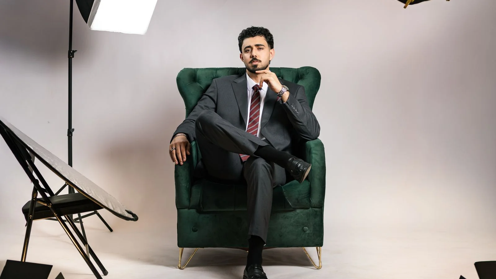 A businessman poses confidently in a clean studio portrait setting