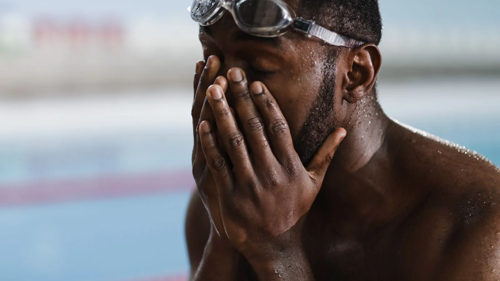 An athlete resting poolside with goggles and water on their skin, the recovery routine a protocol has to fit into