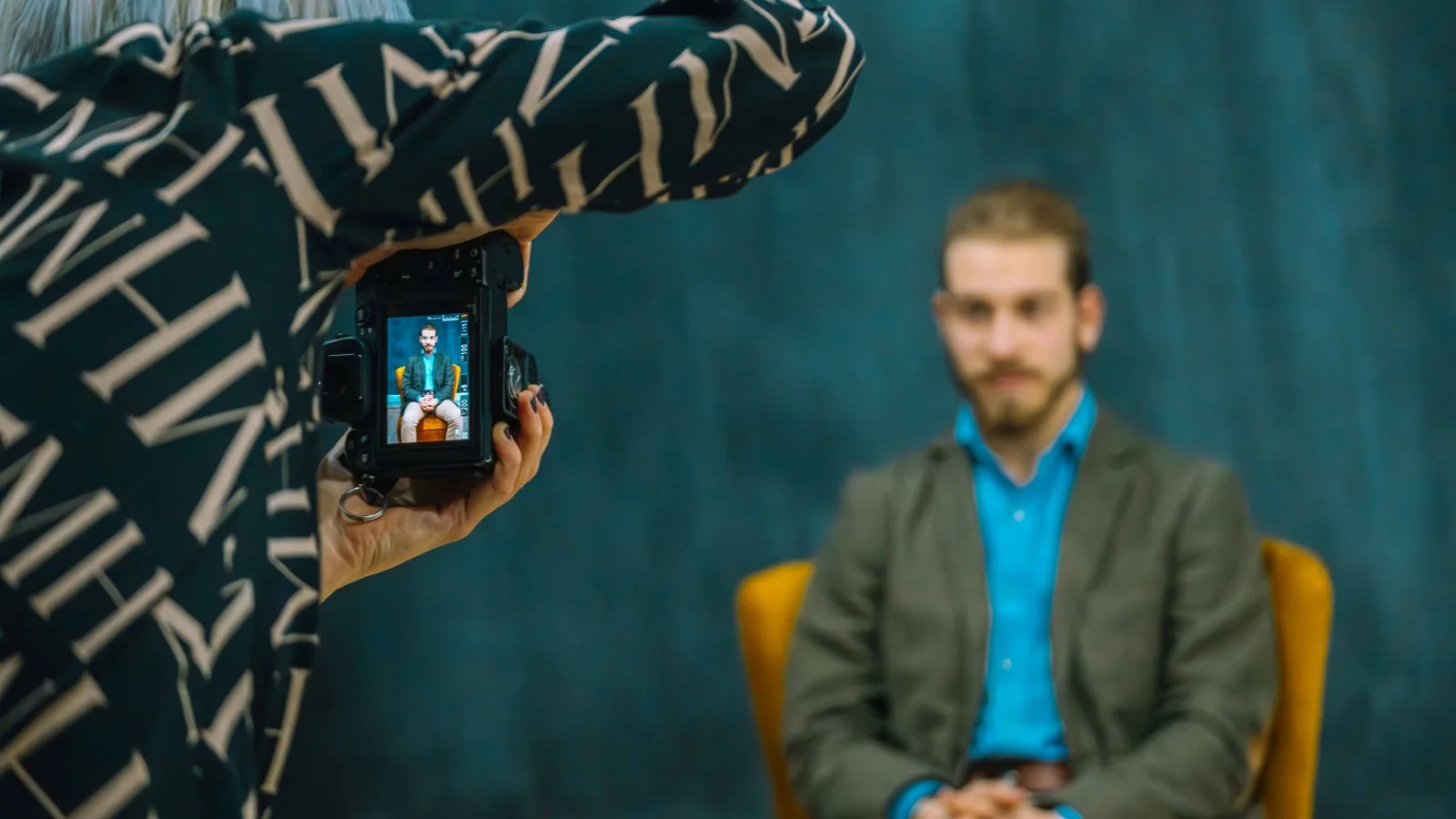 Photographer taking a male portrait in a studio, the kind of controlled image most developers never sit for.