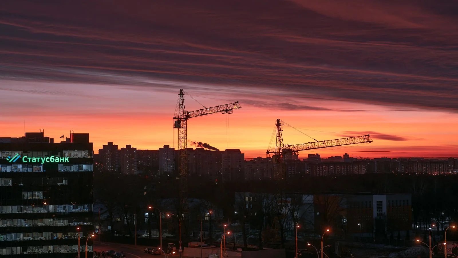 Construction site with cranes against a sunset skyline, the kind of delivered project a credit officer wants your name attached to.