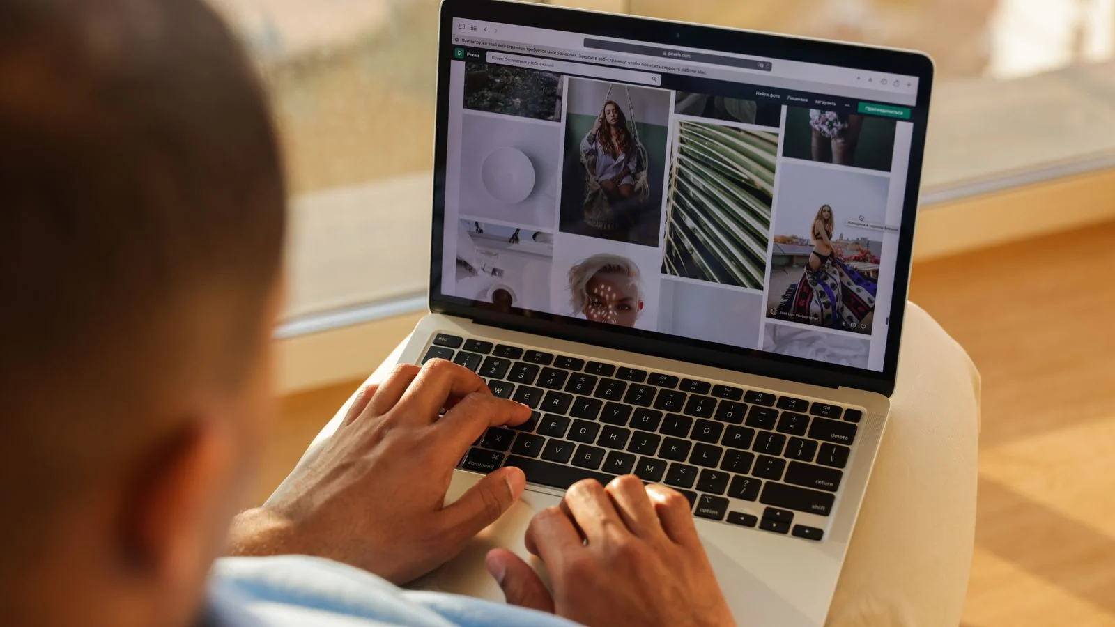 A person using a laptop indoors, browsing search results and profiles.