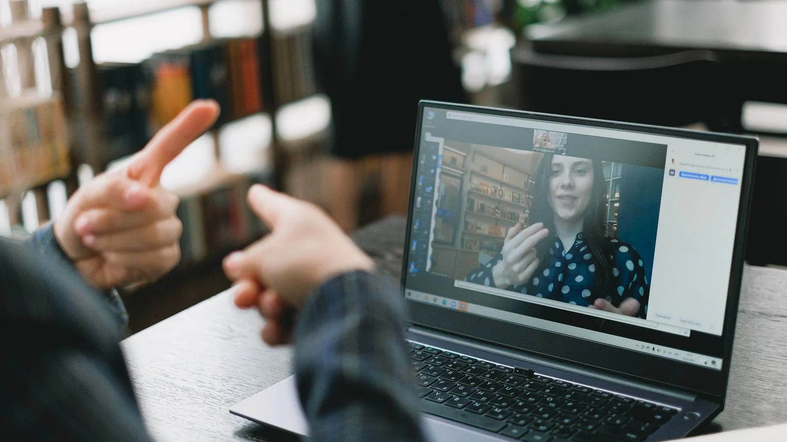 A professional on a video call at a laptop, sharing expertise with an audience.
