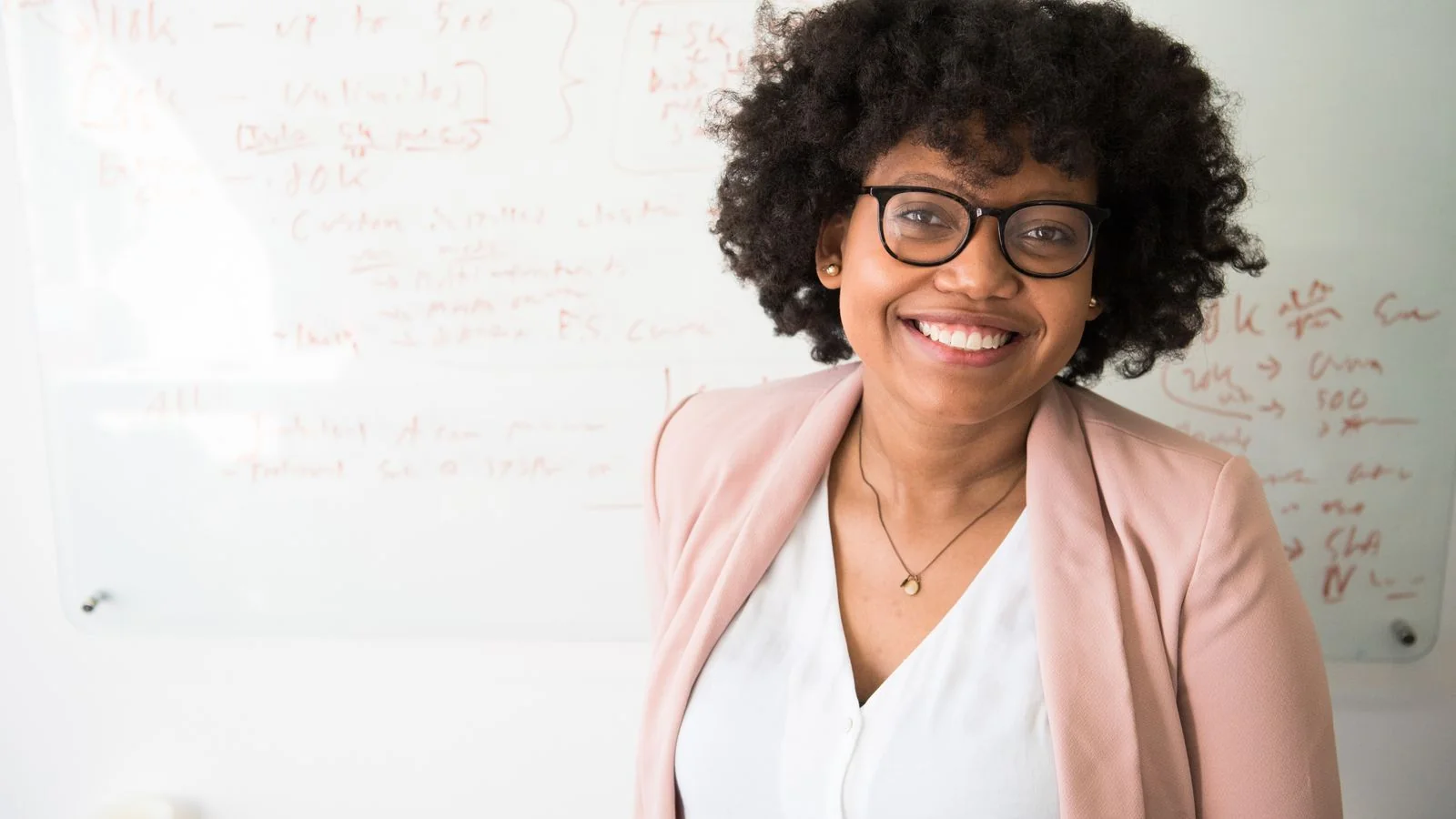 Escrow officer smiling at her desk, the face agents think of when they hear the company name.