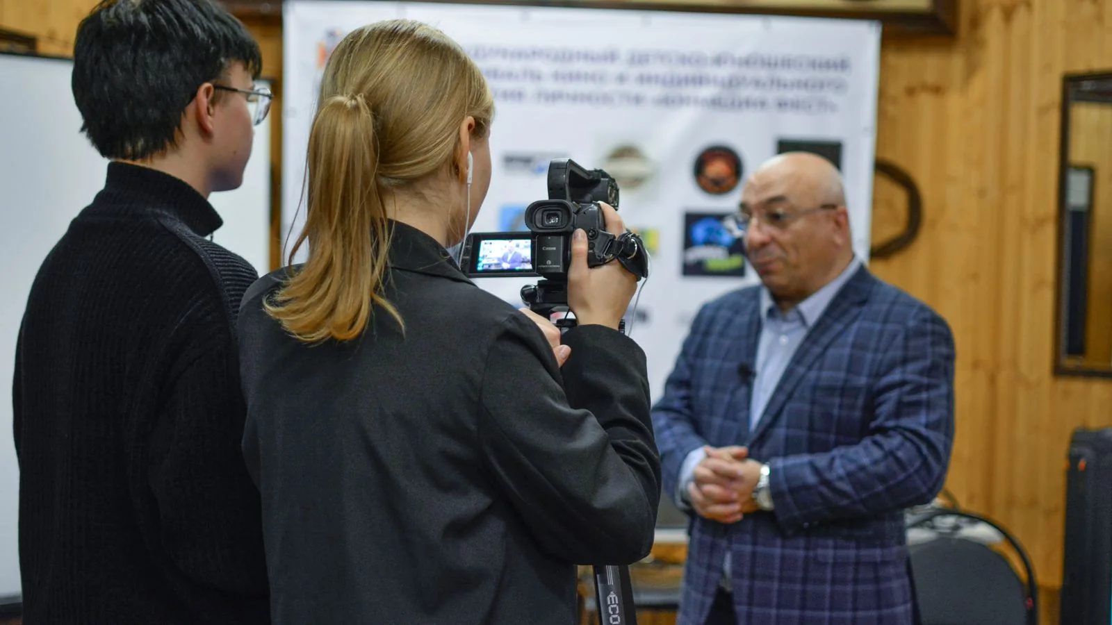 A small camera on a tripod recording a person talking