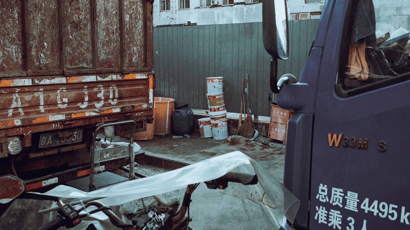 Industrial yard with parked trucks and storage containers, where a hauler owner's day starts before dawn.