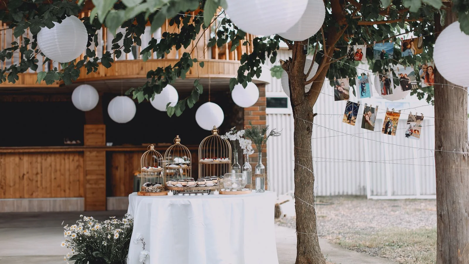 A garden reception dressed with a dessert table and ambient lighting, the kind of setup suppliers photograph and circulate.