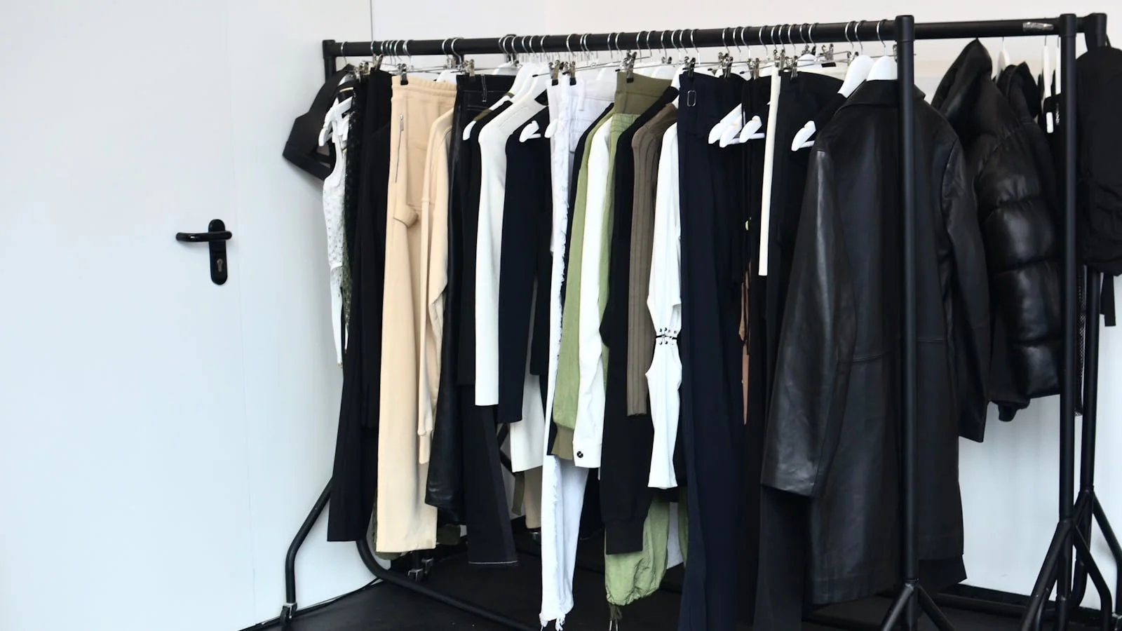 Stylish wardrobe rack with curated outfits hanging in a studio in preparation for a personal branding photoshoot
