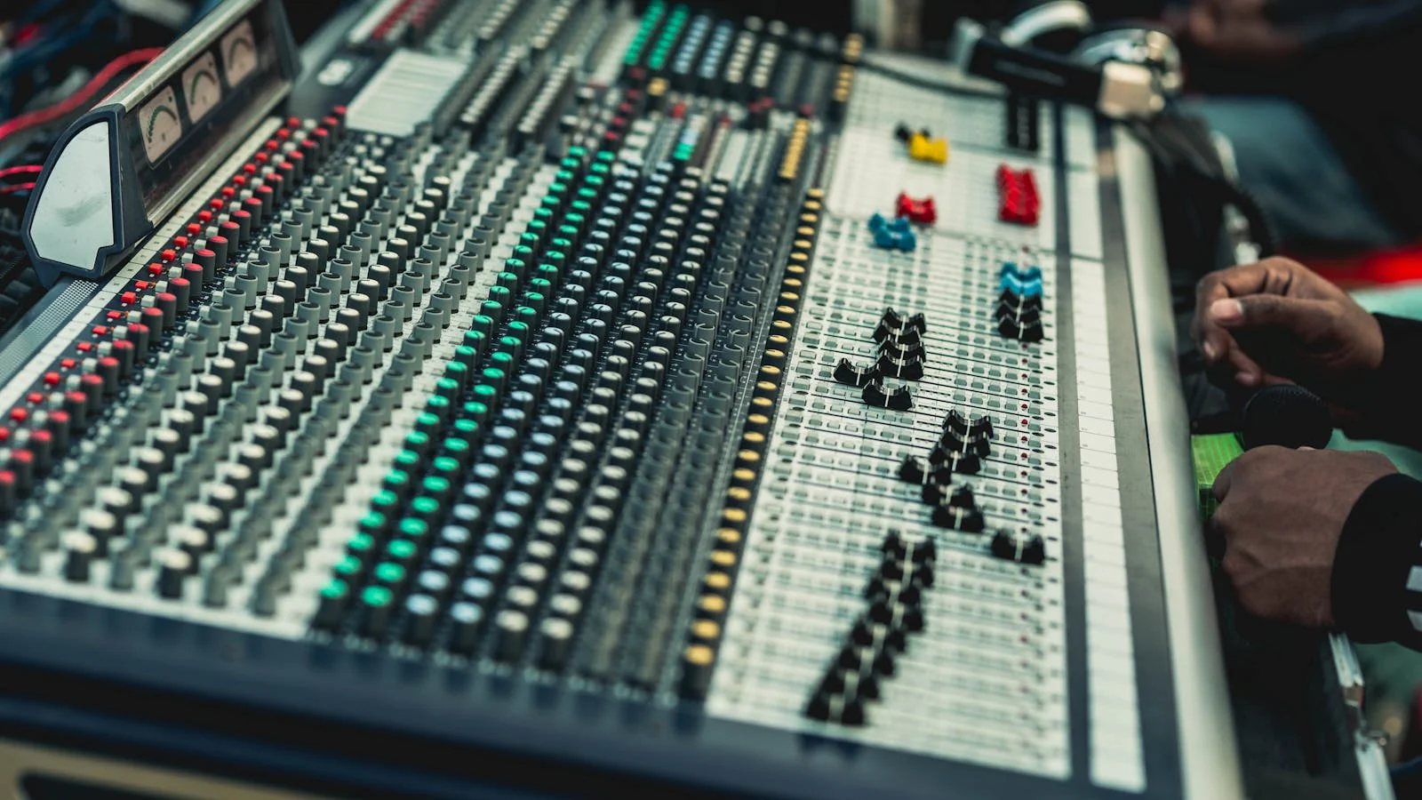 A close-up of an audio mixer console in a recording studio, the technical layer behind every clean podcast appearance that compounds into citation.