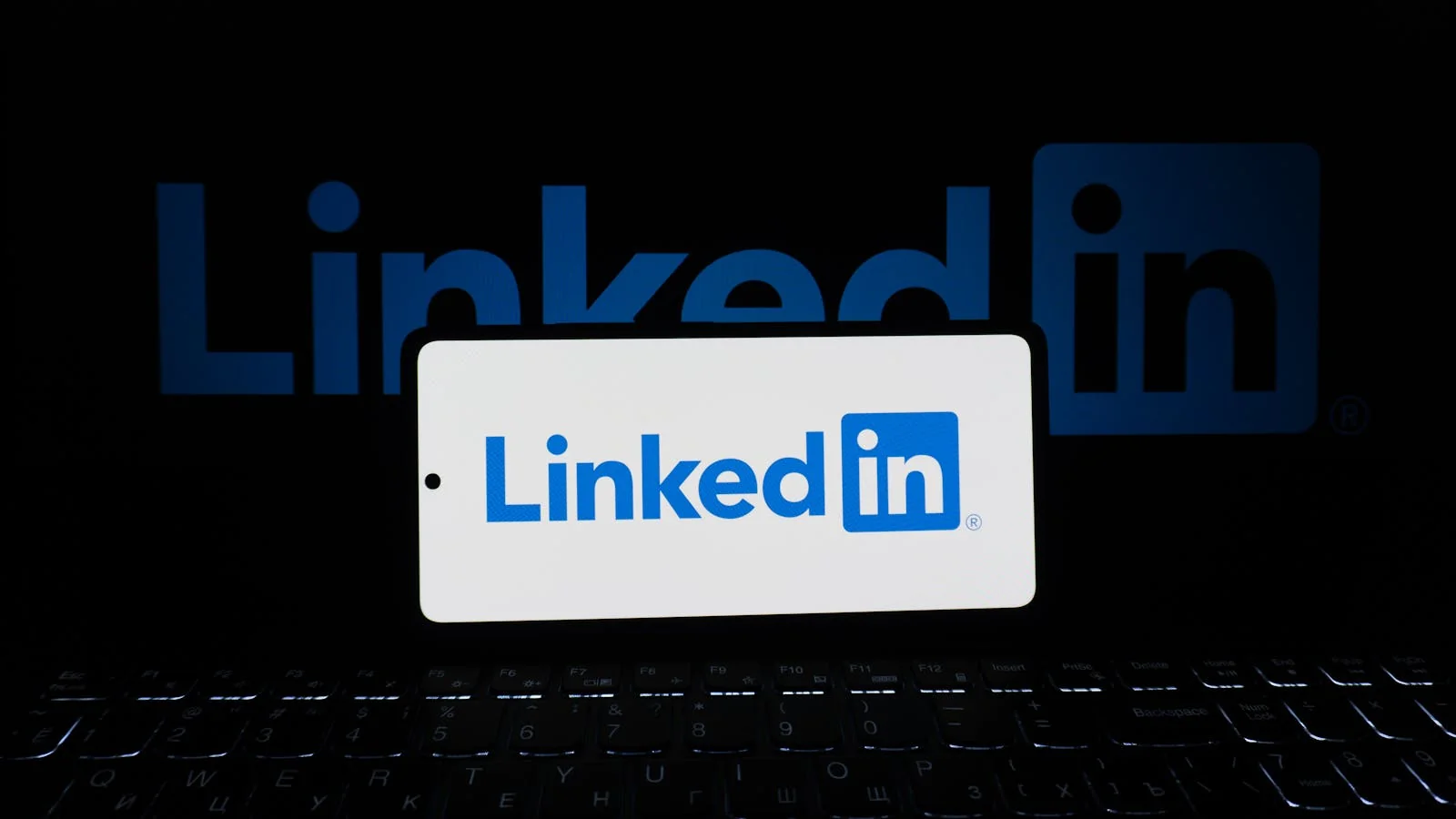 LinkedIn logo glowing on a smartphone screen, the surface where most founder personal brands compound