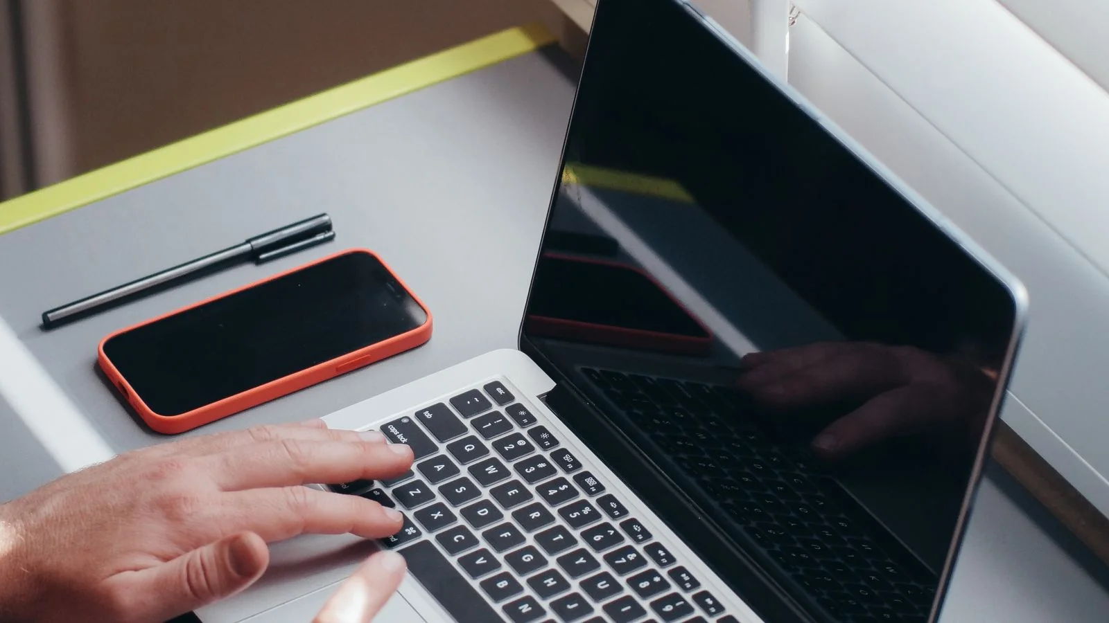 Hands typing on a laptop at a bright desk, the research work of matching a story to a reporter's beat