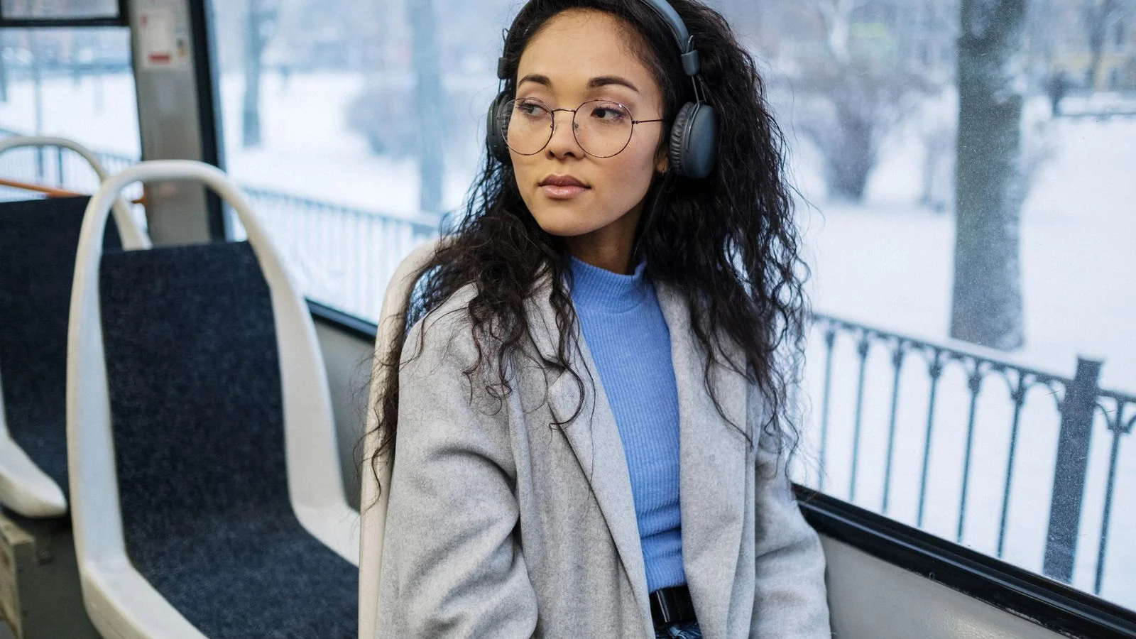 A woman listening through wireless headphones outdoors, the attention digital audio actually captures