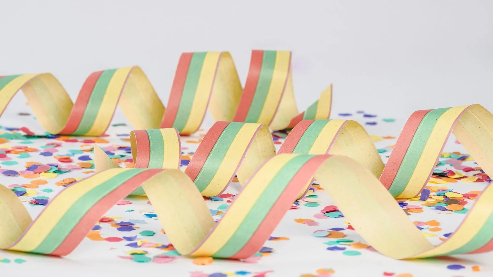 Colorful paper streamers and confetti scattered across a surface after a celebration