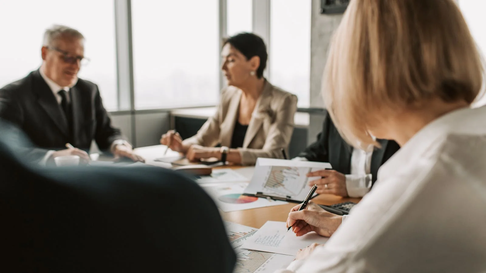 Colleagues reviewing documents together in a corporate office meeting