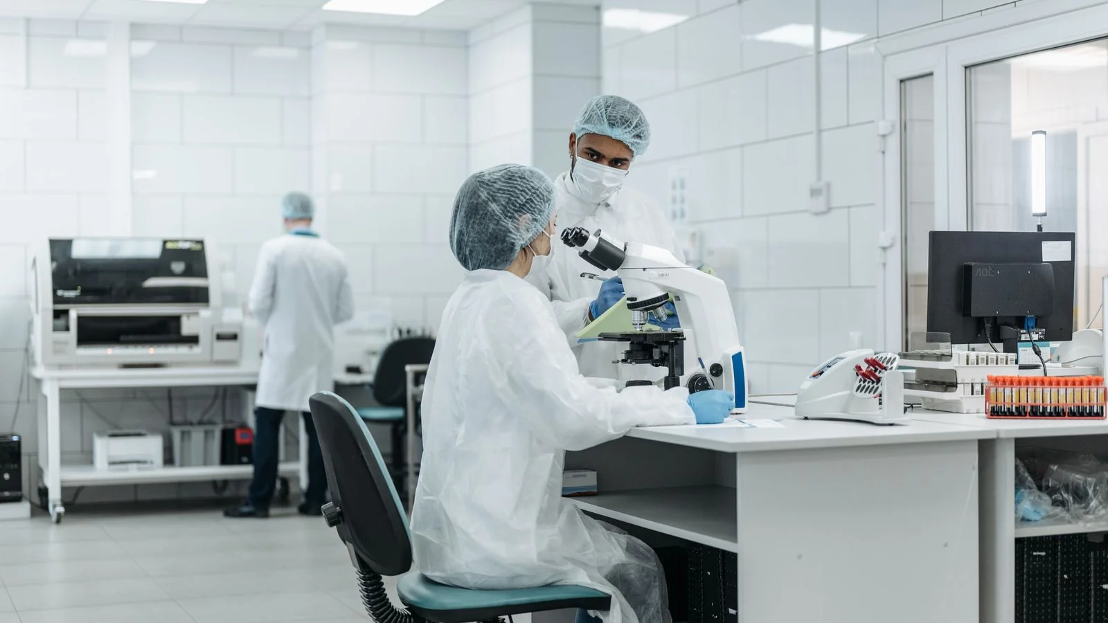 Researchers working with lab equipment, the data a careful biotech announcement has to state precisely.
