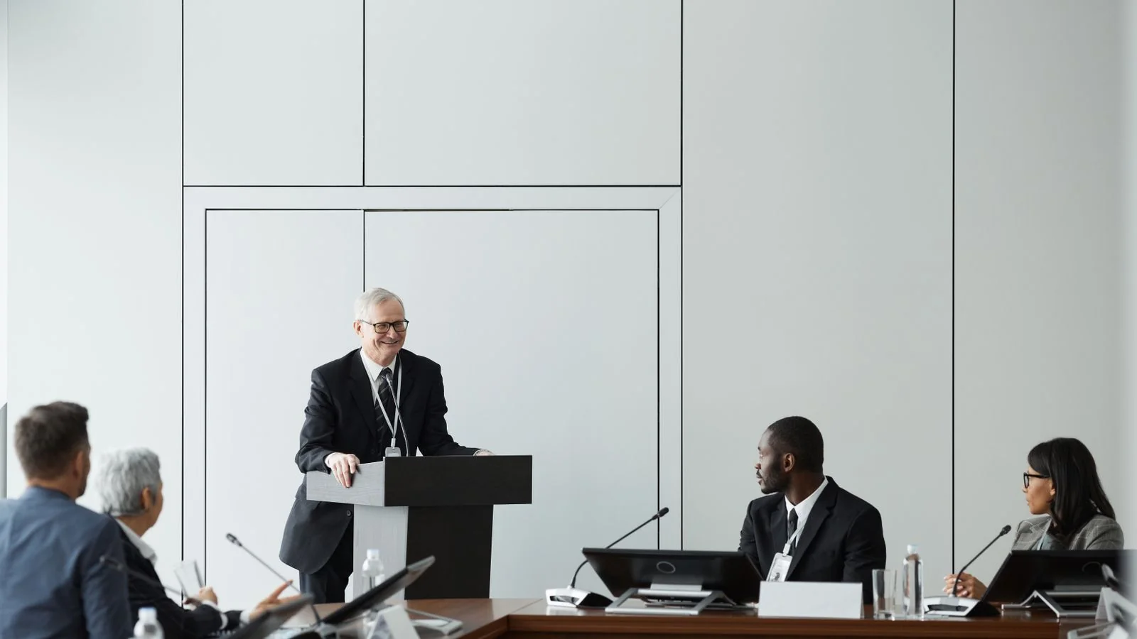 A speaker addressing a formal meeting from a podium, the announcement moment you only get once