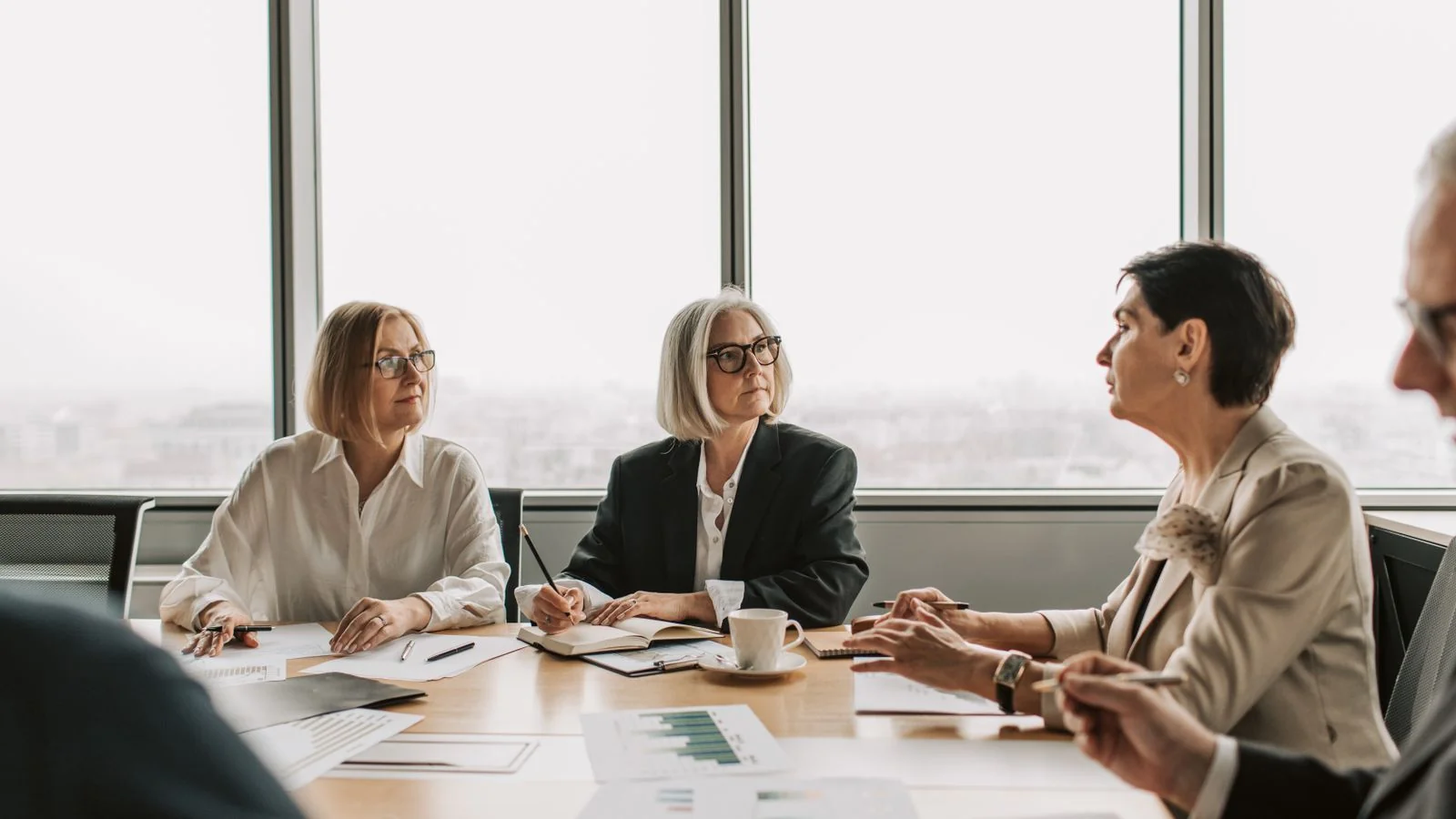 Senior executives in a serious discussion around a table, where the wording gets decided
