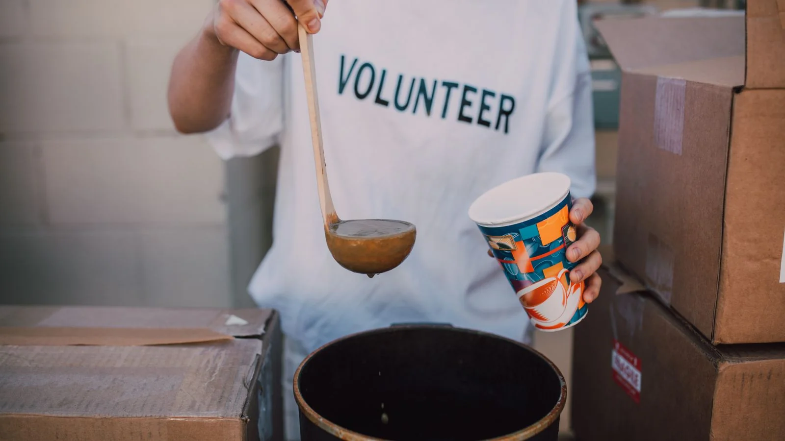 A volunteer serving soup at a community meal, the kind of measurable impact a CSR release should lead with