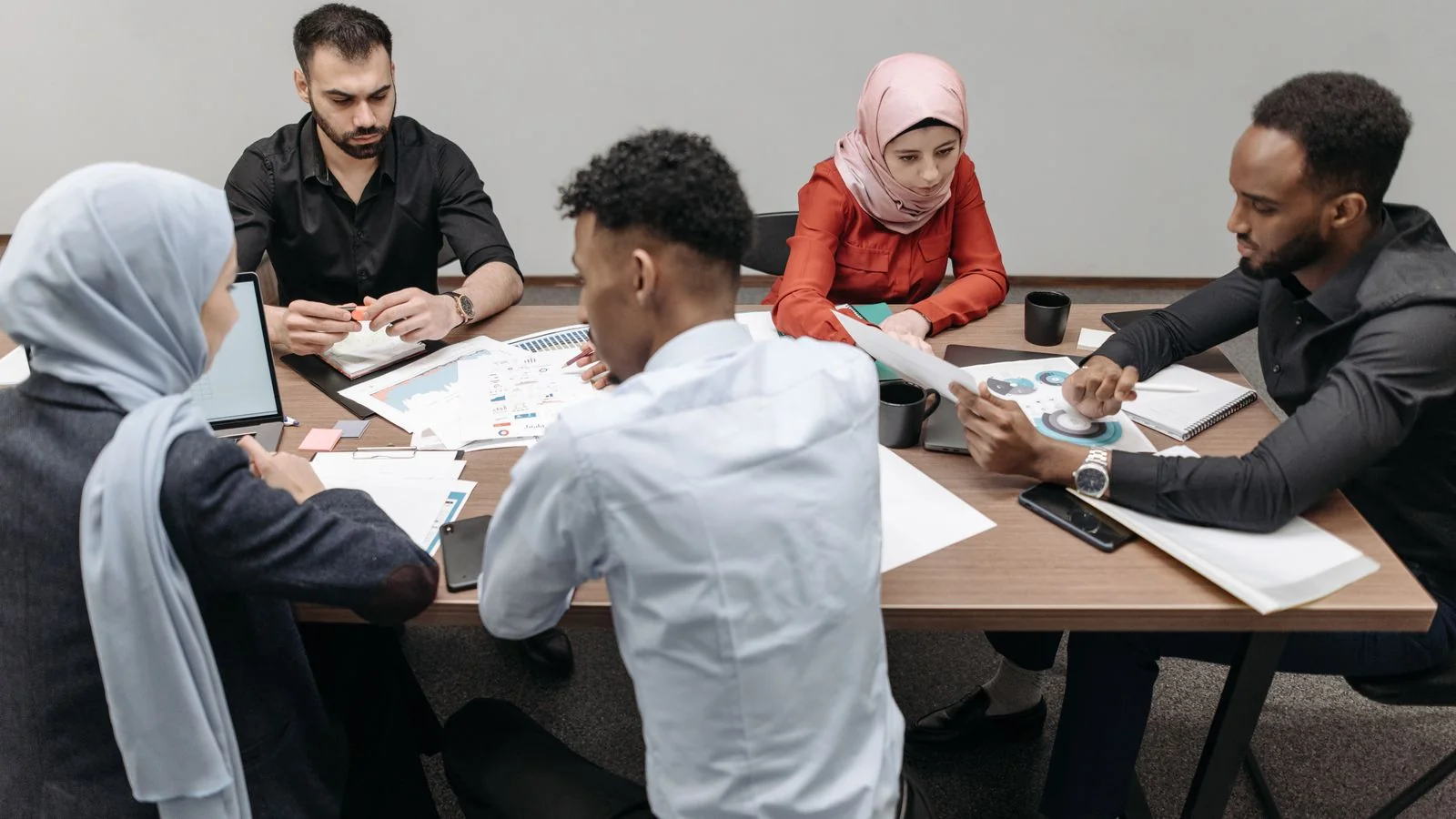 Diverse professionals in a collaborative meeting, the sustained work a results-based announcement can point to