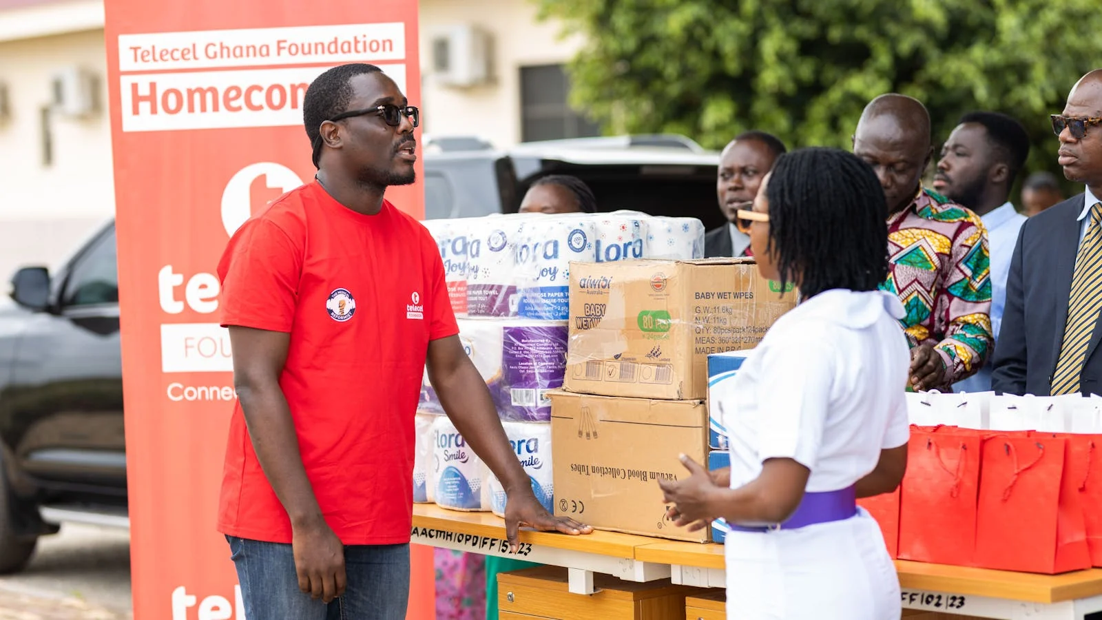Volunteers distributing donated items at a community drive, the visible outcome a donation press release should describe