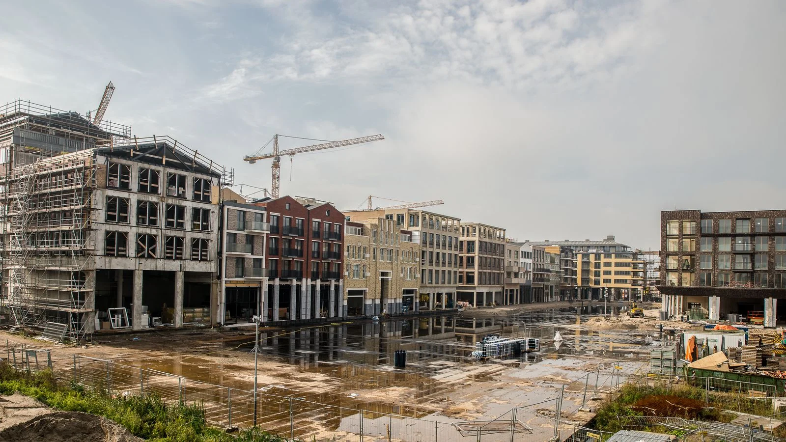 Construction cranes over a new commercial building site, the expansion story readers actually care about
