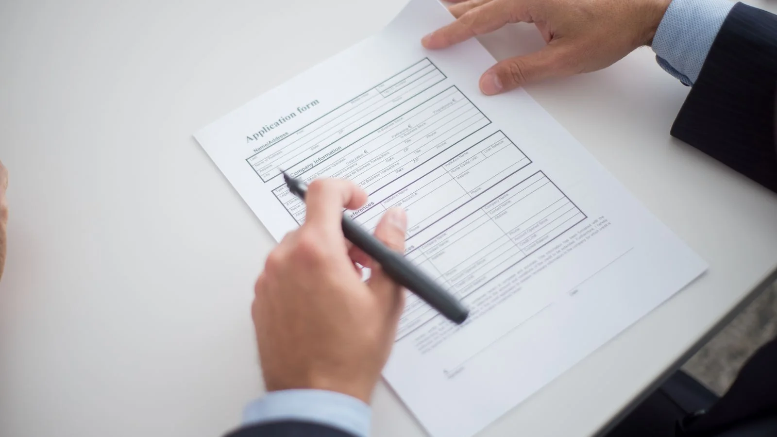 Close-up of someone reviewing an application form at a desk, the paperwork behind every award
