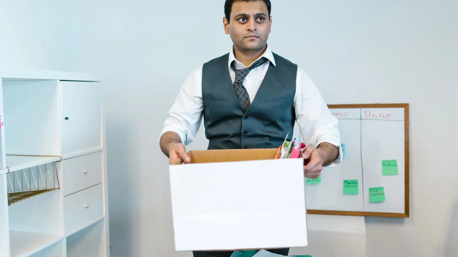 Someone packing personal items into a cardboard box, the reality the document describes