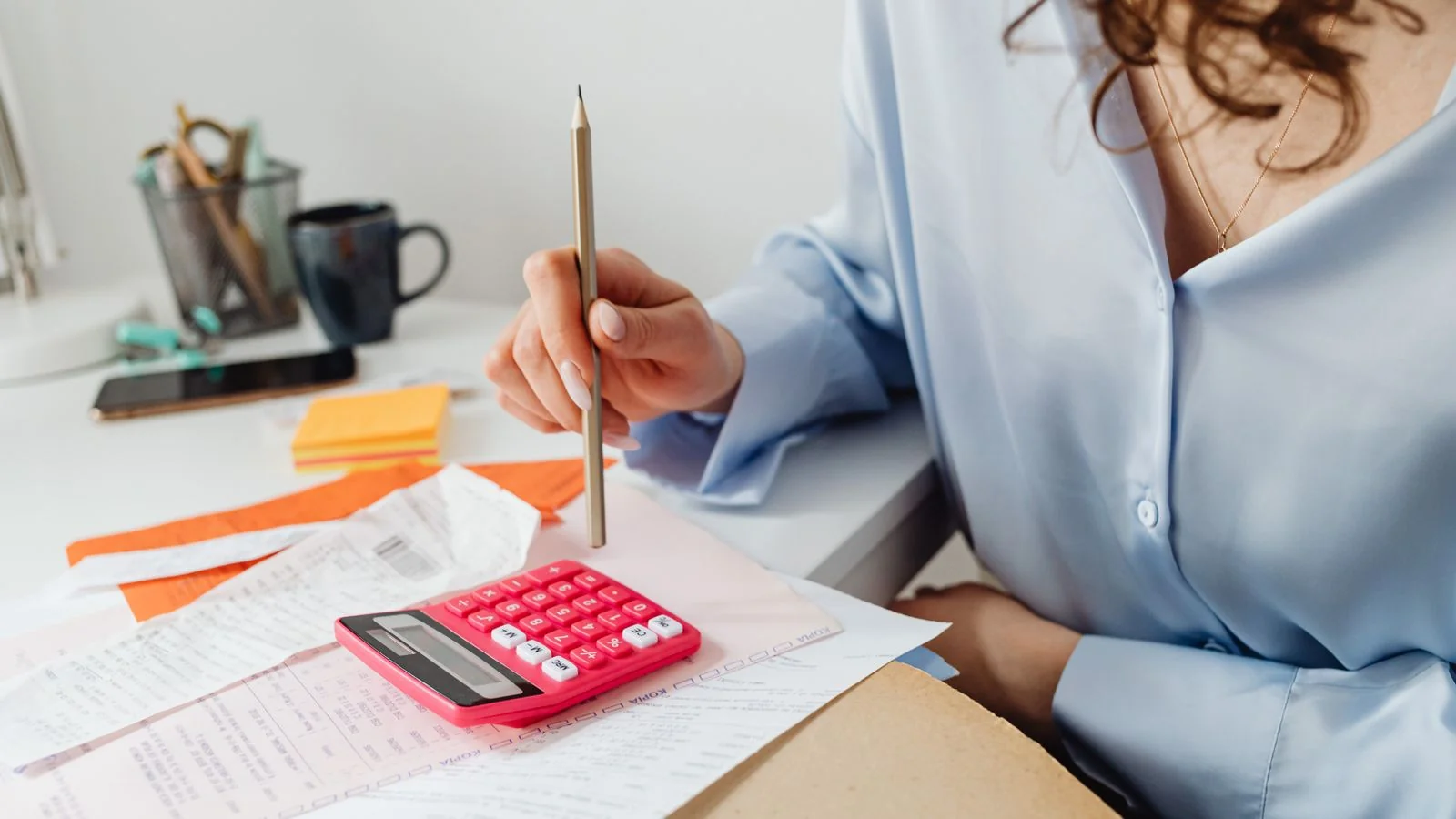 Invoice paperwork and a calculator on a desk, the arithmetic behind the announcement decision