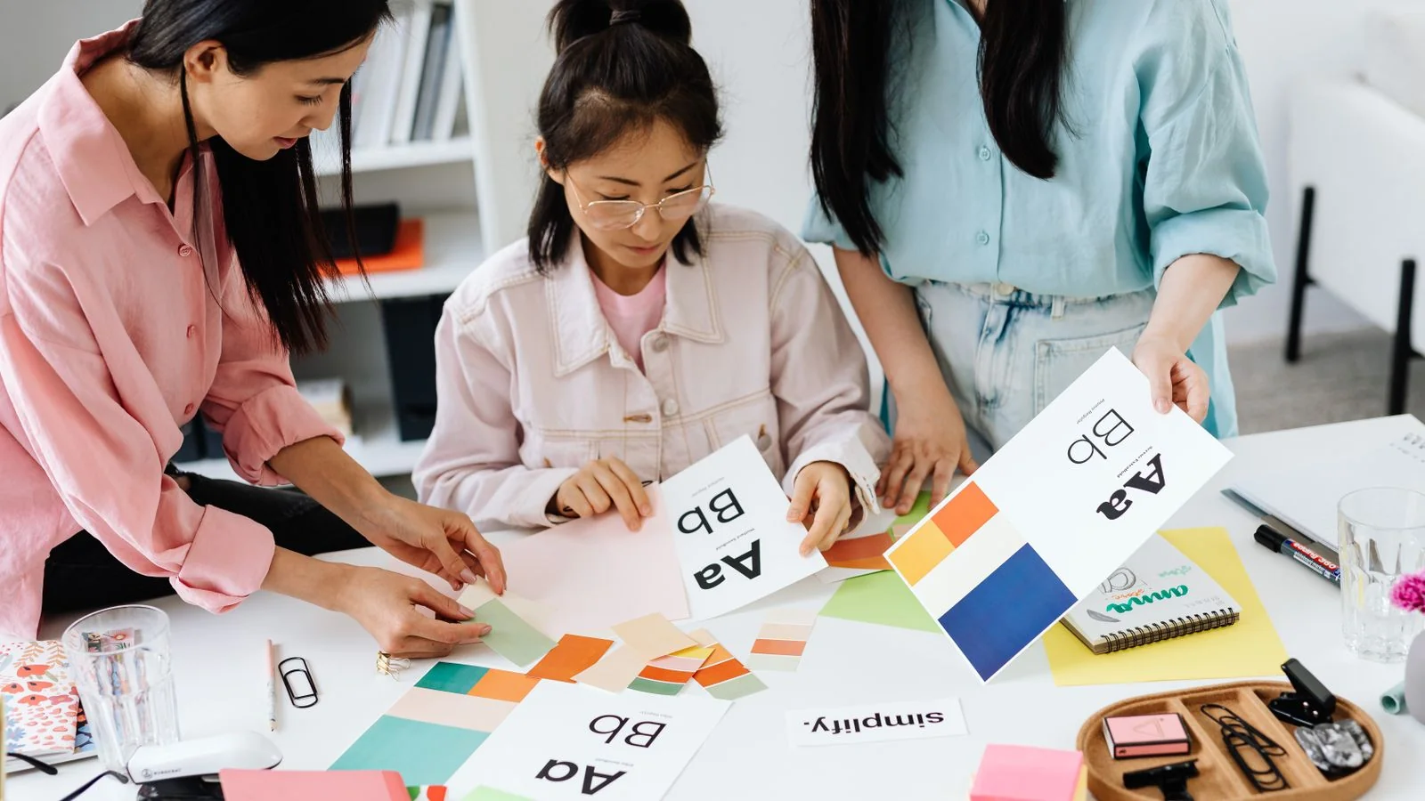 Designers comparing color samples for a new brand identity, the change a rebrand has to explain