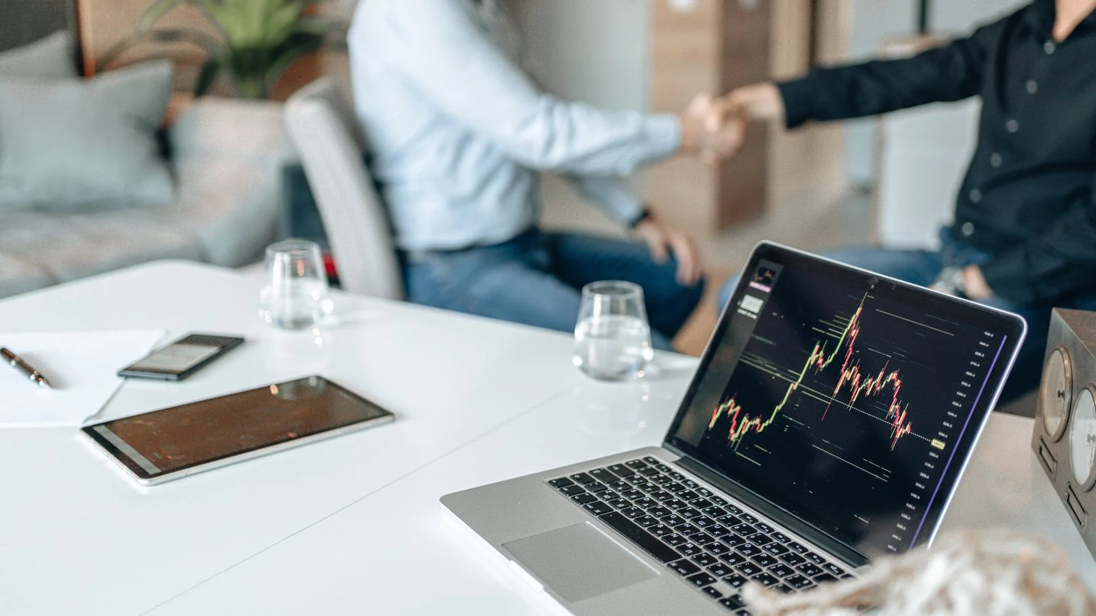 Two professionals shaking hands over a laptop showing performance data, the proof points that anchor a round