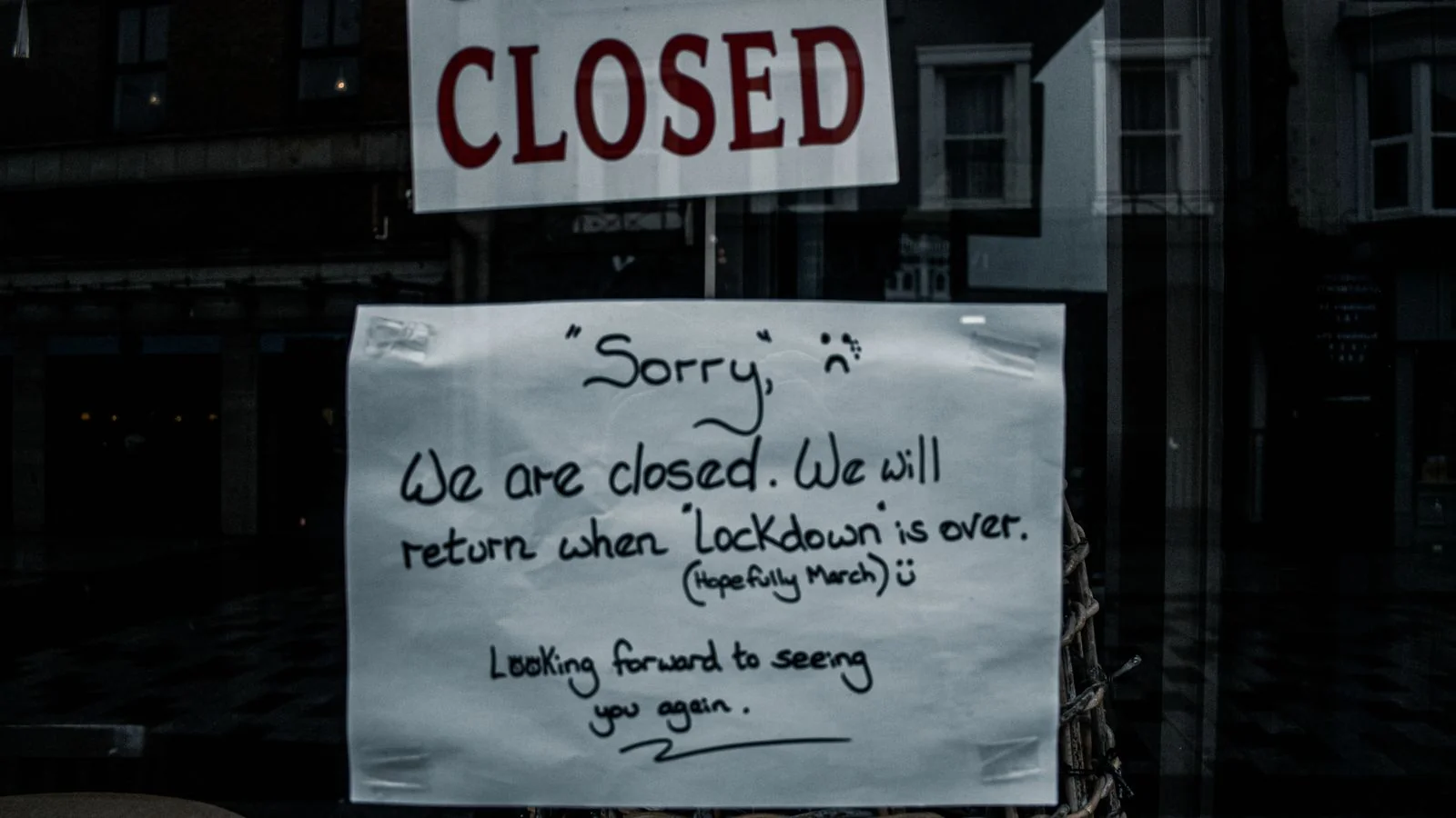 Printed notice taped inside a shop window announcing the end of trading