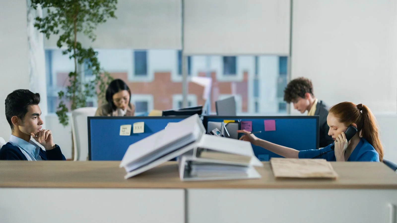 Newsroom with reporters working at open desks, where pitches compete for a few seconds of attention each