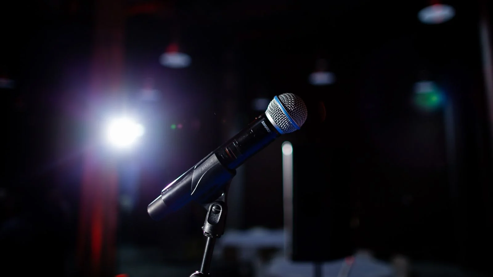 Microphone on a stand under a spotlight, the live event a media advisory invites journalists to attend