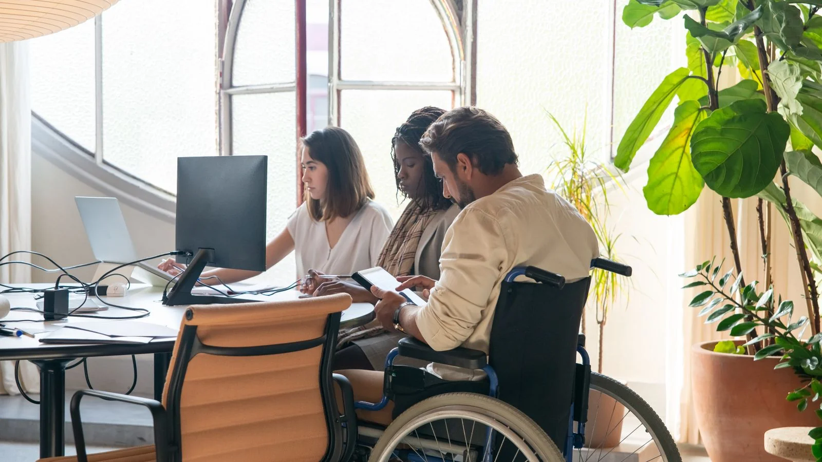 Diverse team collaborating in a modern office, the kind of lean group that buys self-serve tools